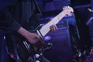 Someone playing a guitar in a band